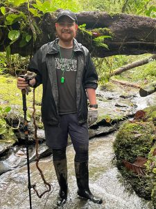 Patrick Wright standing on a trail holding a walking stick